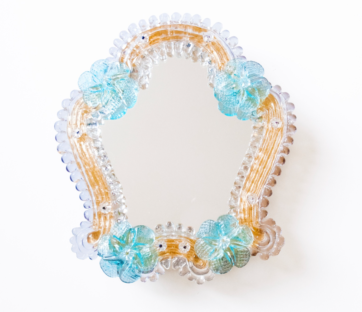 A frontal view of Anami Alchemia's ornate yoni viewing mirror in blue colour way, against a plain white background. 